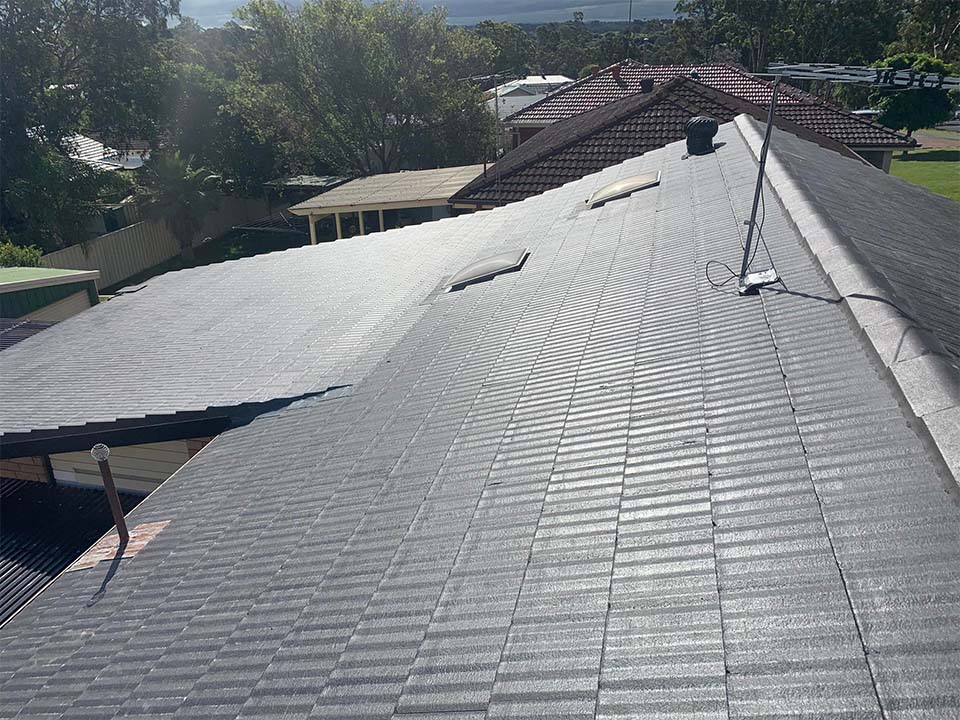 After: the same tiled roof, now clean and charcoal grey