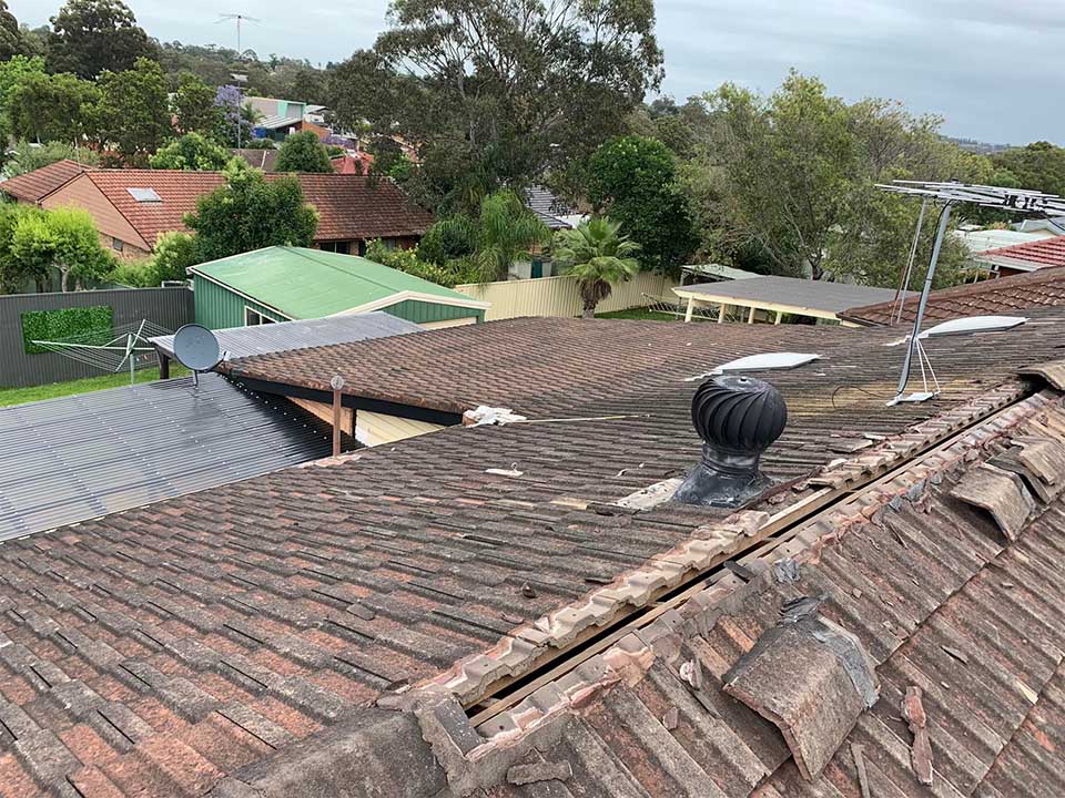Before: weathered brown tiled roof with broken ridge capping and a whirlybird