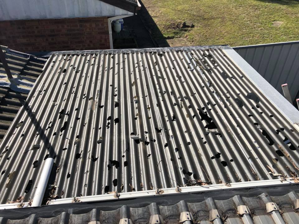 Before: rusted corrugated patio roof full of holes beside a tiled roof