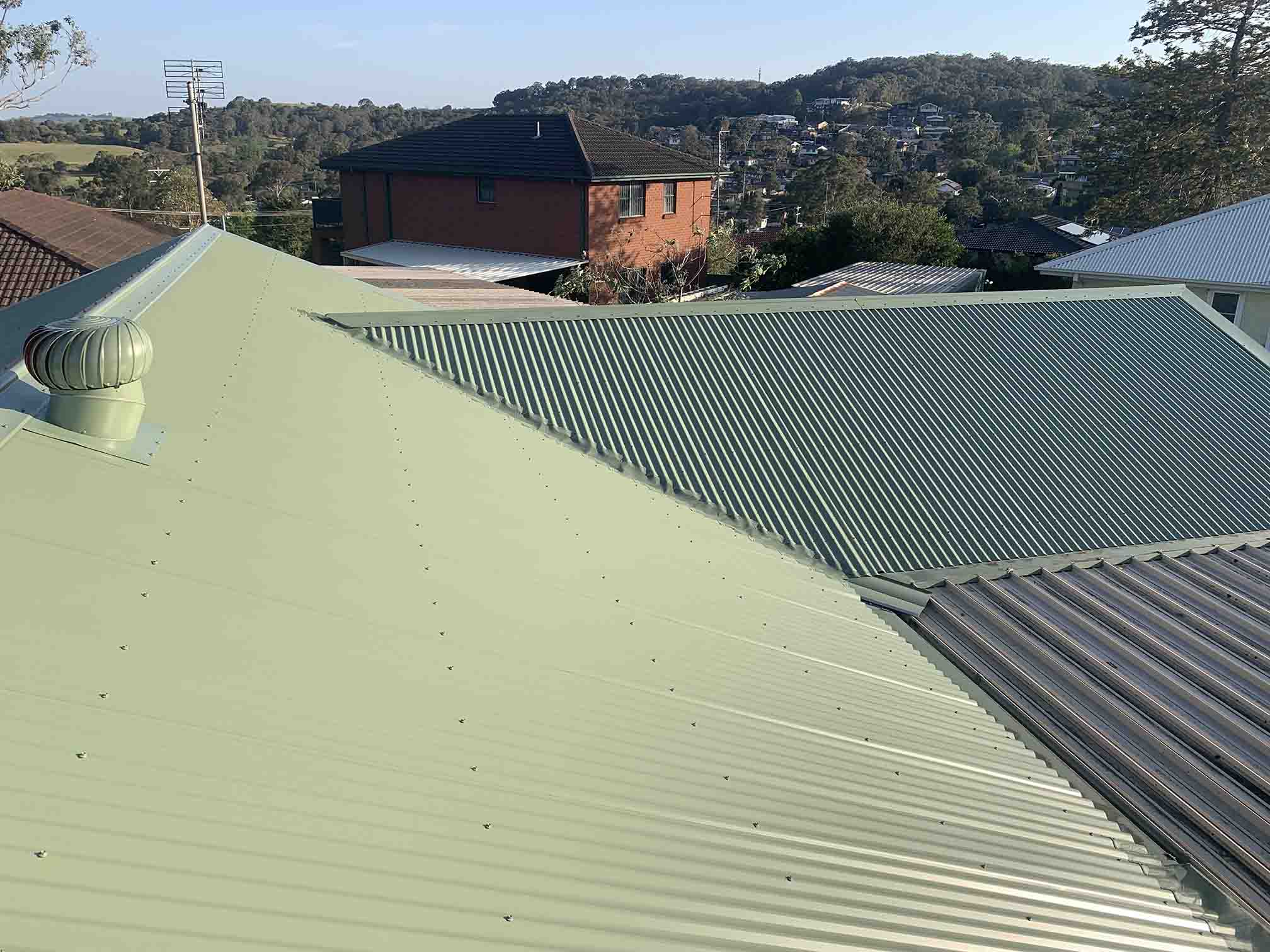 Pale green corrugated metal roof with a whirlybird vent