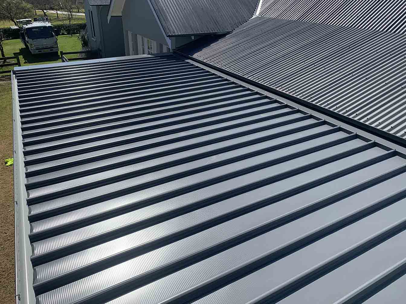 Charcoal ribbed metal roof sheets meeting at a long valley