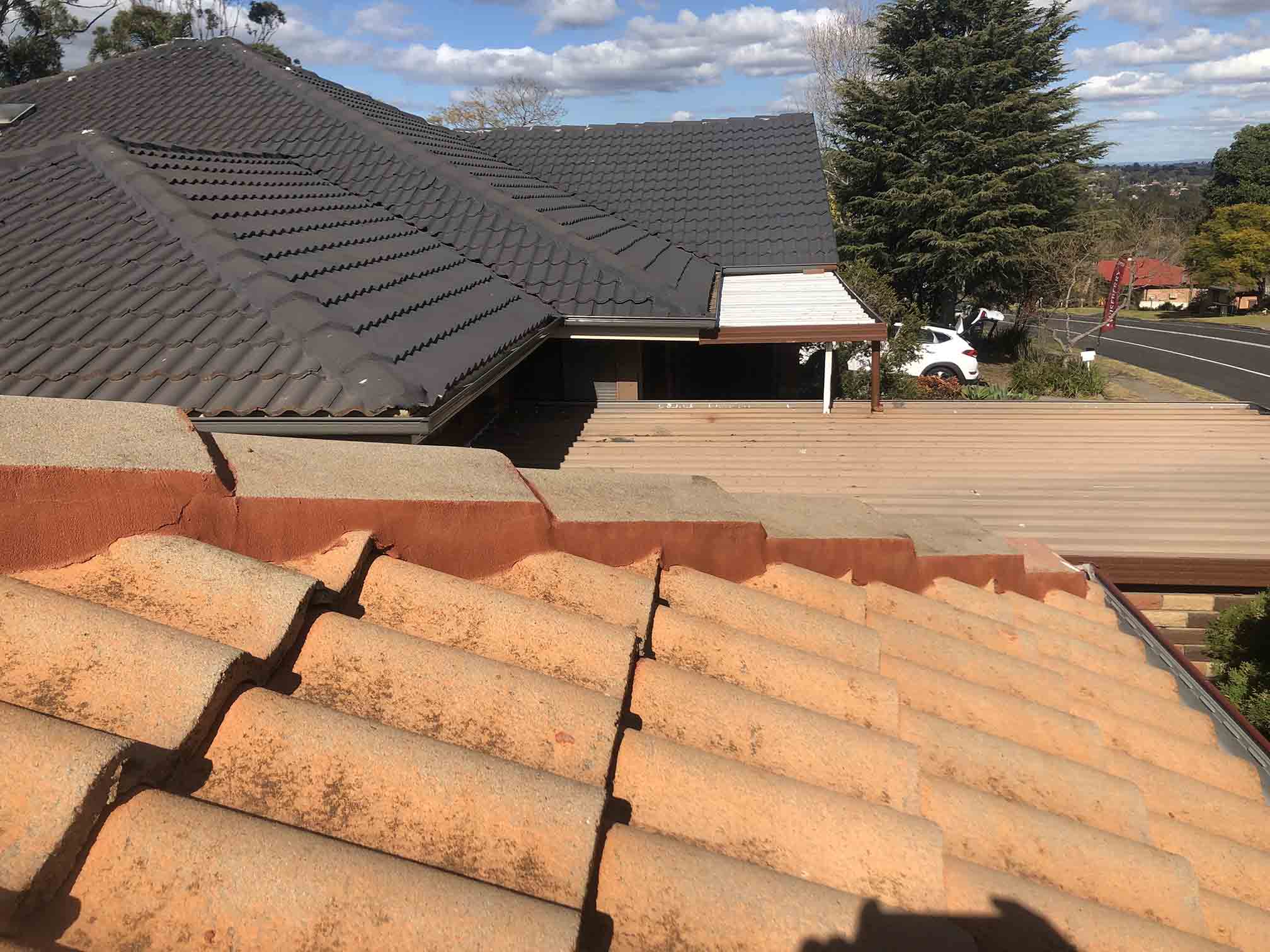 Close-up of terracotta roof tiles with a dark tiled roof behind