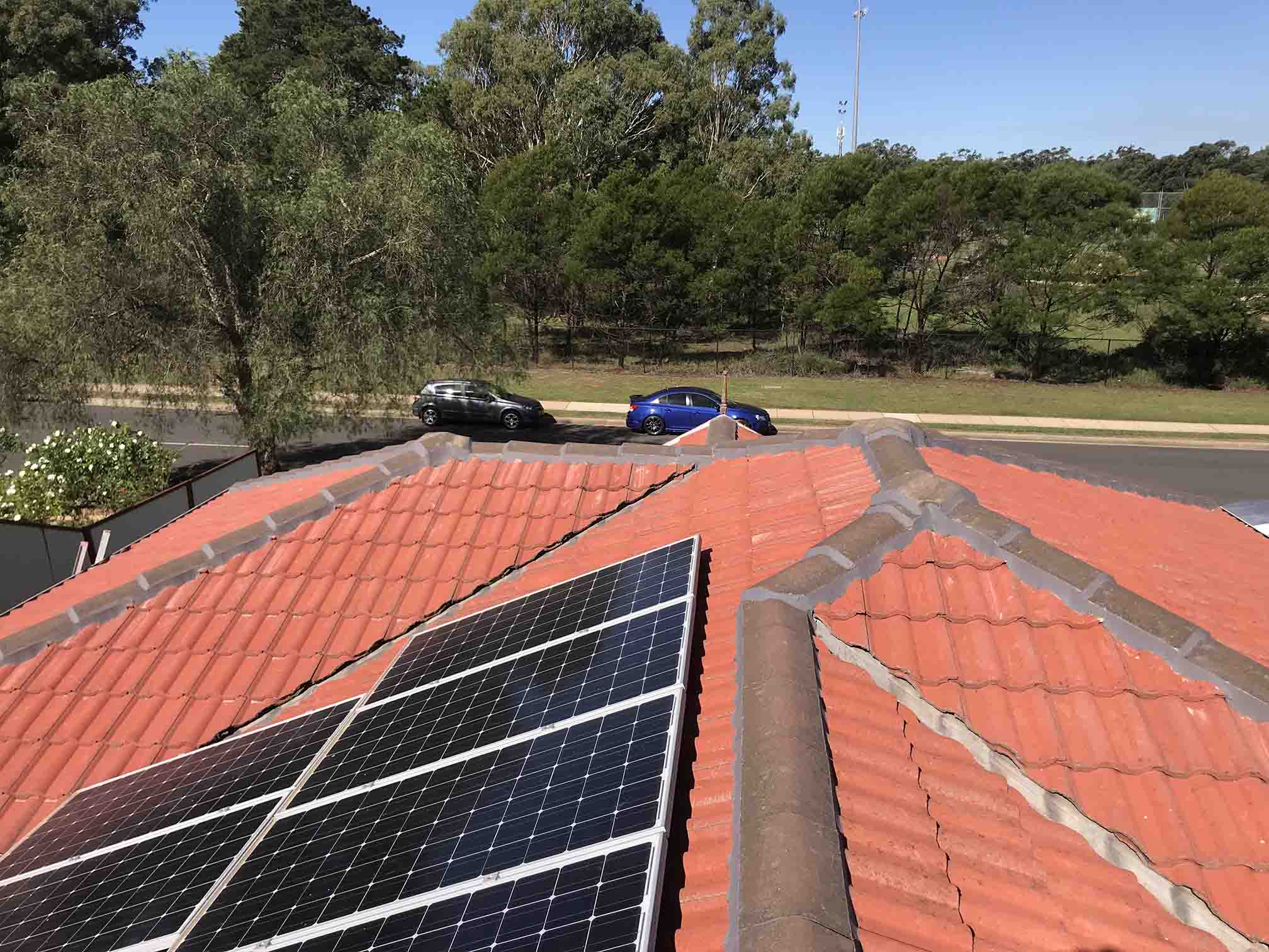 Terracotta tiled roof with solar panels and grey ridge capping